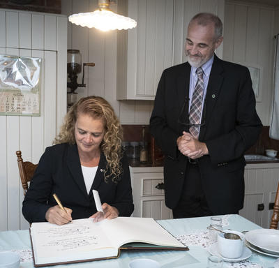 The Governor General signing the guest book at the Maison Alphonse-Desjardins.