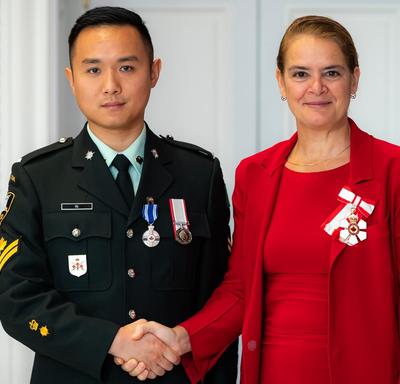The Governor General shakes hands with Master Corporal Yu.