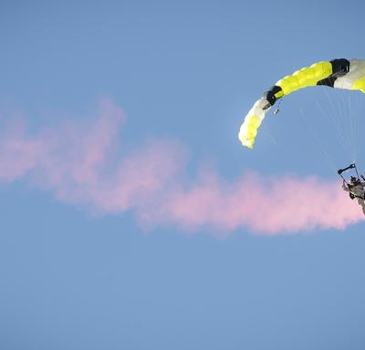 Un membre des Forces armées canadiennes descend du ciel en parachute. 