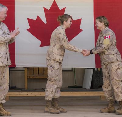 La gouverneure générale Julie Payette serre la main d'un membre des Forces armées canadiennes. 