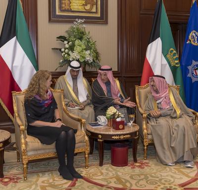 La gouverneure générale Julie Payette est assise avec trois hommes koweïtiens. Des drapeaux colorés sont derrière eux.