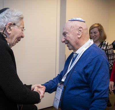Two Holocaust survivors shake hands. 