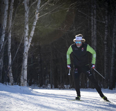A competitive cross-country skier racing down a trail.