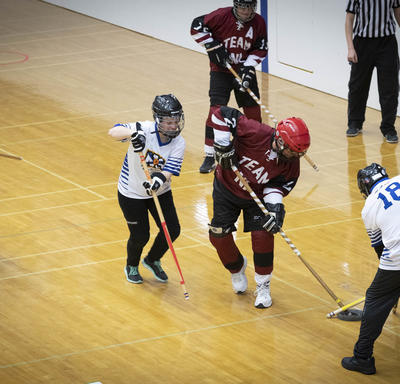 Des athlètes des Jeux olympiques spéciaux sur le terrain lors d'une partie de hockey intérieur. 