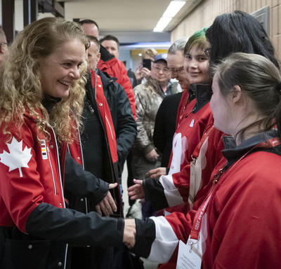 Dressed in Canada red, the Governor General shakes hands with Special Olympics athletes after their game.
