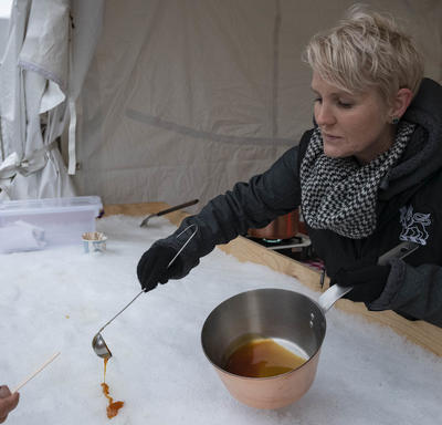 A Rideau Hall employee pours maple taffy onto ice during the Winter Diplomatic Reception. 