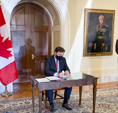 L’administrateur est assis à une table. Le secrétaire se tient à sa gauche.