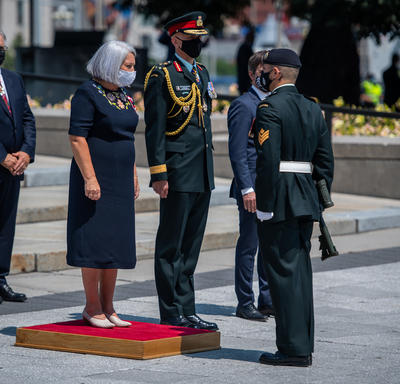 La gouverneure générale Mary May Simon se tient sur une petite plateforme rouge devant le Monument commémoratif de guerre du Canada.