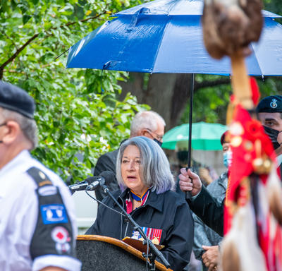 The Governor General delivers her speech. She is outdoors. It is raining.