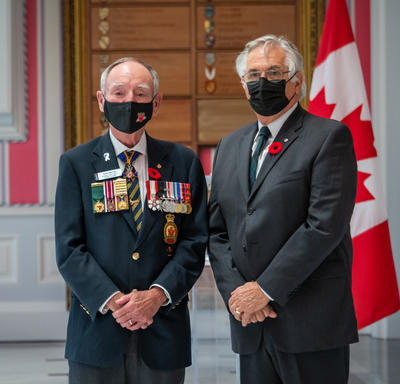 Mr. Whit Grant Fraser, who also took part in the ceremony, received a poppy from Mr. Larry Murray, Grand President of the Royal Canadian Legion.