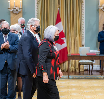 Their Excellencies are shown entering the Tent Room at Rideau Hall. The audience is shown standing and applauding them.