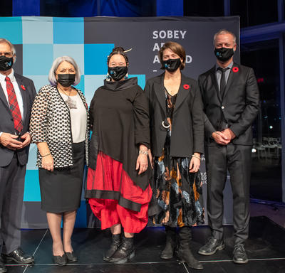 Leurs Excellences se tiennent à la droite du gagnant du Prix Sobey pour les arts 2021. Deux autres personnes se tiennent à la gauche du lauréat.