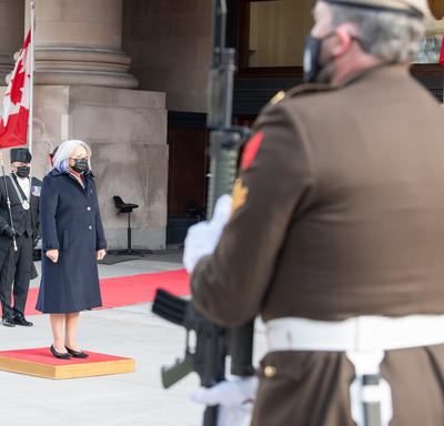 La gouverneure générale se tient sur une petite plate-forme rouge à l'extérieur du Sénat.