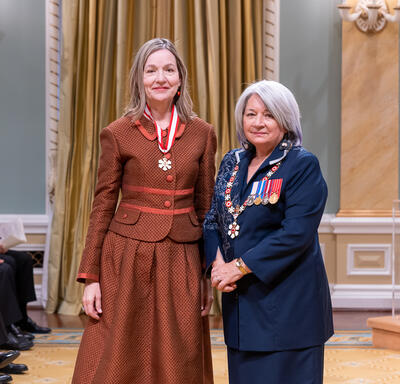 Marcia Vaune Jocelyn Kran is standing next to the Governor General.
