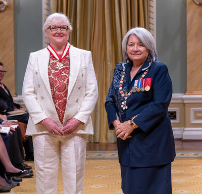 Lori West is standing next to the Governor General.