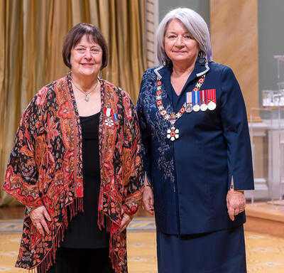 Carol Pearl Herbert is standing next to the Governor General.