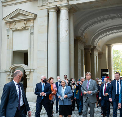 Her Excellency walking with members of the German government. The Canadian delegation is following behind. Some people are wearing masks.