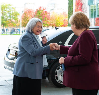 Her Excellency greeting Angela Merkel.