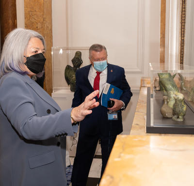 La gouverneure générale Mary Simon regarde un objet exposé à la Maison du Canada.