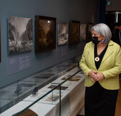 Governor General Mary Simon is touring a historical exhibit and inspecting different displays.