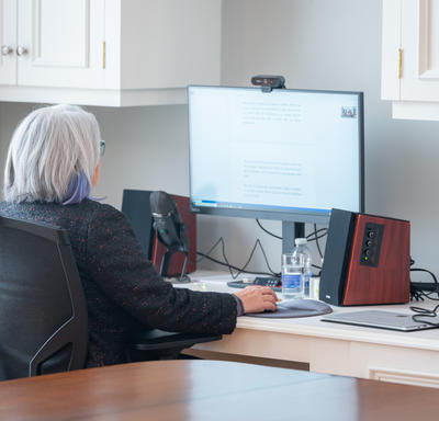 La gouverneure générale est assise devant un ordinateur. Elle participe à un événement virtuel.