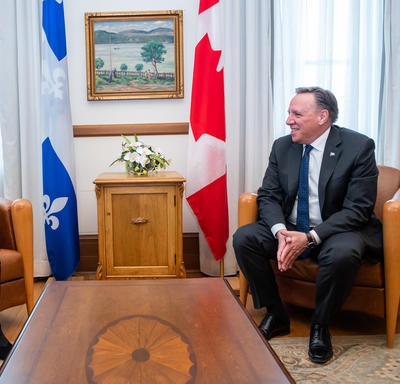 Her Excellency is pictured speaking with the Premier of Quebec. They are both seated and smiling at one another.