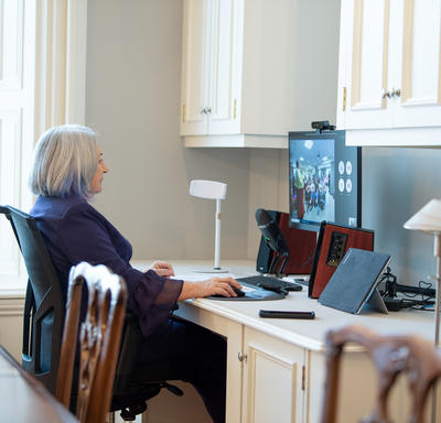 The Governor General is sitting at a computer. She is participating in a virtual event.