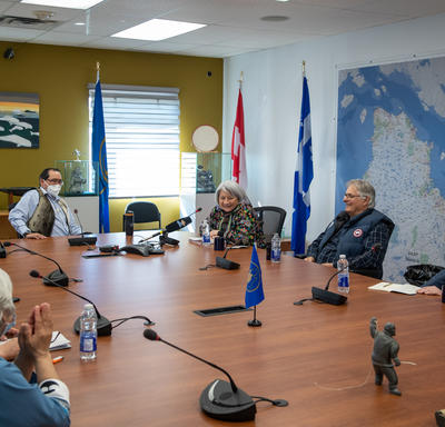 La gouverneure générale est assise à une grande table de conférence avec plusieurs autres personnes.