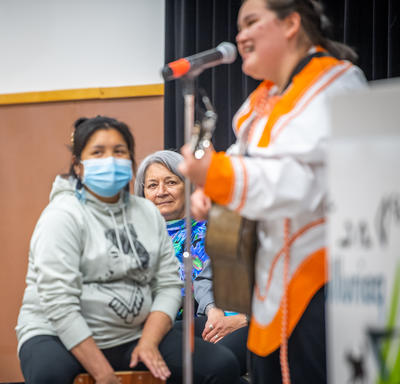 Une femme joue de la guitare sur scène.