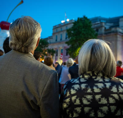 A photo taken from behind Governor General Simon and Mr. Fraser, who are watching the lighting of the Queen’s Platinum Jubilee Beacons. 