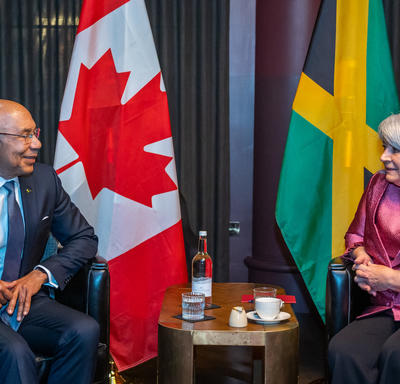 La gouverneure générale Simon et le gouverneur général de la Jamaïque, Patrick Allen, sont assis l’un en face de l’autre. Il y a une table entre eux. 