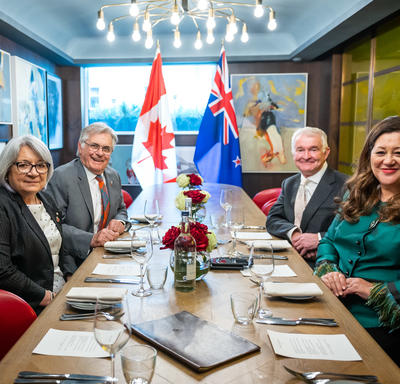 La gouverneure générale Simon et Dame Cindy Kiro, gouverneure générale de Nouvelle-Zélande, sont assises à une grande table. Leurs maris sont également présents.