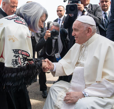 Governor General Simon is shaking hands with Pope Francis.