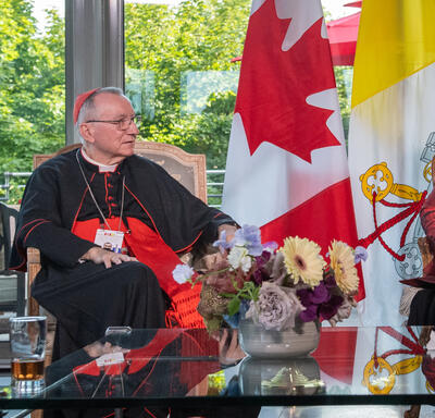 Governor General Simon is sitting next to His Eminence Cardinal Pietro Parolin in a room at the GGCitadelle. They are talking to each other.