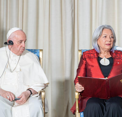 La gouverneure générale Simon est assise à côté de Sa Sainteté le pape François dans une salle du GGCitadelle. Elle a un livre ouvert sur ses genoux.
