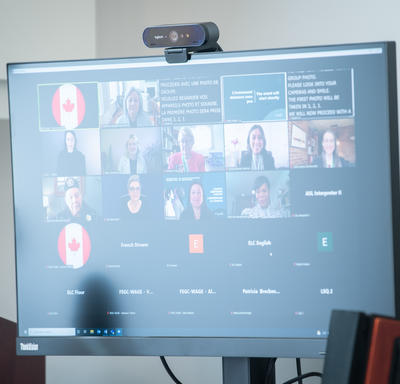 Vue d'un écran d'ordinateur montrant des panneaux de photos de plusieurs participants. Une cérémonie virtuelle est en train de se dérouler.