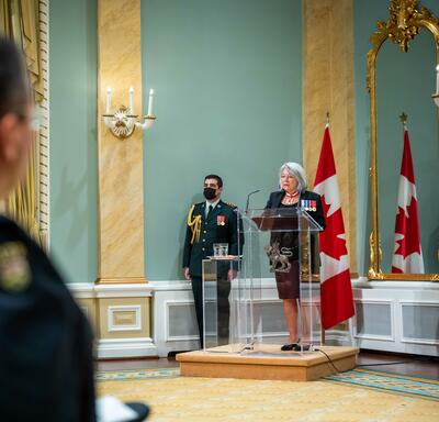 La gouverneure générale se tient derrière un pupitre dans la salle de bal de Rideau Hall.