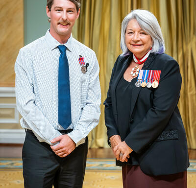 Bravery recipient Trevor Vanderhyden is standing next to the Governor General.