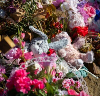 A mound of flowers and stuffed animals. 