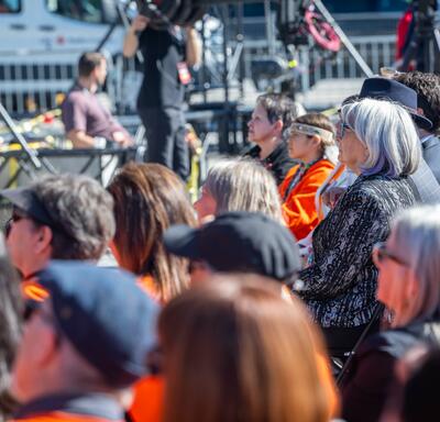 The Governor General is in the crowd, looking up towards the stage.