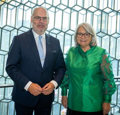La gouverneure générale Mary Simon est debout à côté de Son Excellence, Alar Karis, président de la République d'Estonie. Il y a un grand mur de verre à motifs derrière eux.