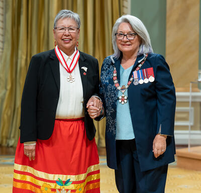 The Honourable Lillian Eva Quan Dyck is standing next to the Governor General.