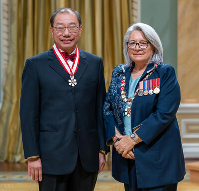 Shoo Kim Lee is standing next to the Governor General.
