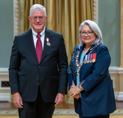 Max Blouw is standing next to the Governor General.