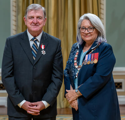 Roger D. Grimes is standing next to the Governor General.