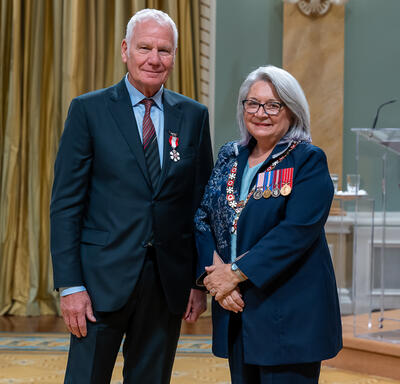 Tony Hauser is standing next to the Governor General.