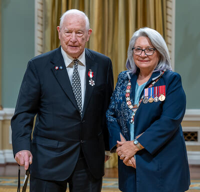 John R. Lacey is standing next to the Governor General.