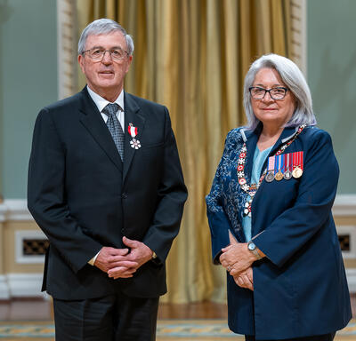 Donald S. Mavinic is standing next to the Governor General.