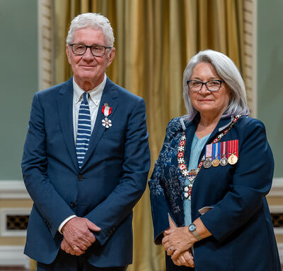 Donald R. M. Schmit is standing next to the Governor General.