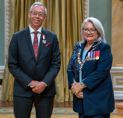 Howard Timothy Lee Soon is standing next to the Governor General.